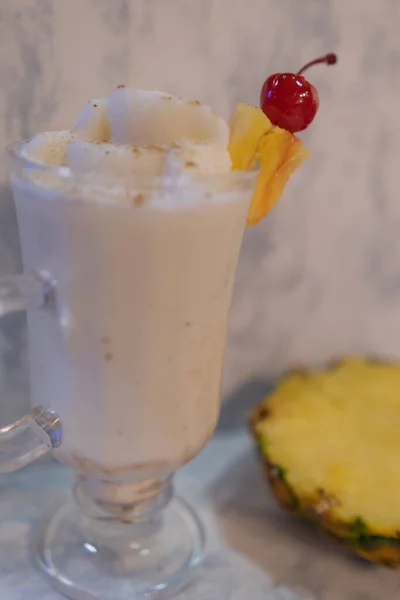 Saboroso milkshake de baunilha e fatia de abacaxi acima do fundo de mármore branco — Fotografia de Stock
