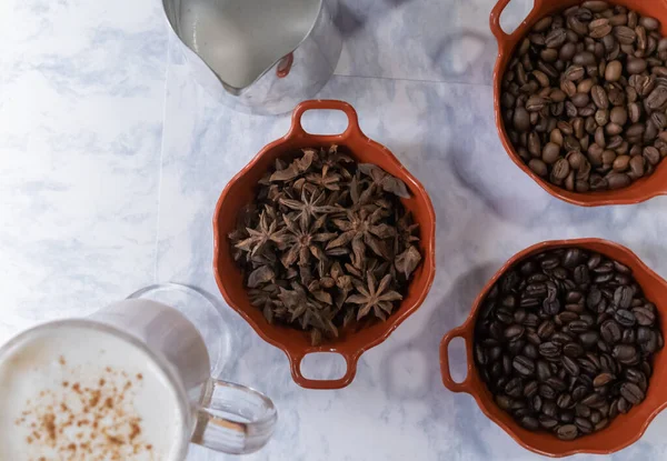 Mjölkshake och grytor av rostade kaffebönor och anis på vit yta — Stockfoto