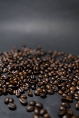 Koyu gri arkaplanlı kavrulmuş kahve çekirdekleri