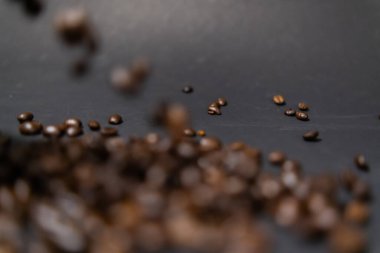 Koyu gri arkaplanlı kavrulmuş kahve çekirdekleri