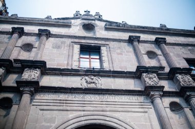 Mavi gökyüzünün altındaki eski Meksika kilisesinin taş sütunları ve duvarları