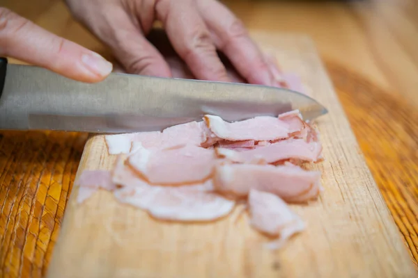 Mains coupant des tranches de jambon de dinde fraîche sur une planche à découper — Photo