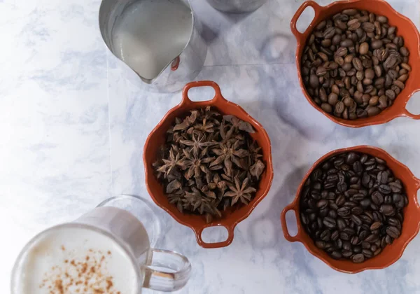 Mjölkshake och grytor av rostade kaffebönor och anis på vit yta — Stockfoto