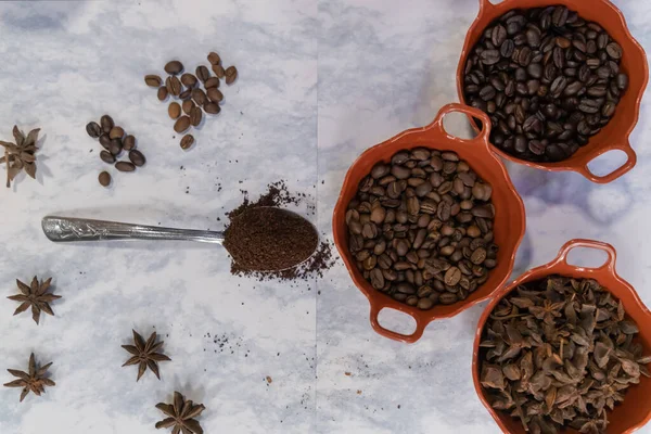 Sked av kaffe och krukor med kaffebönor och anis frön på vit yta — Stockfoto