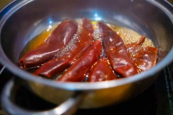 Trockene rote Paprika in Öl im Kochtopf kochen — Stockfoto