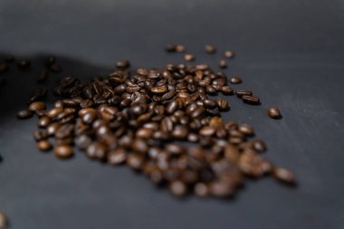 Koyu gri arkaplanlı kavrulmuş kahve çekirdekleri