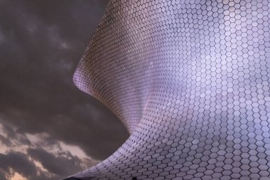 Karanlık bulutlu gökyüzünün altındaki Soumaya Müzesi 'nin alçak açılı görüntüsü