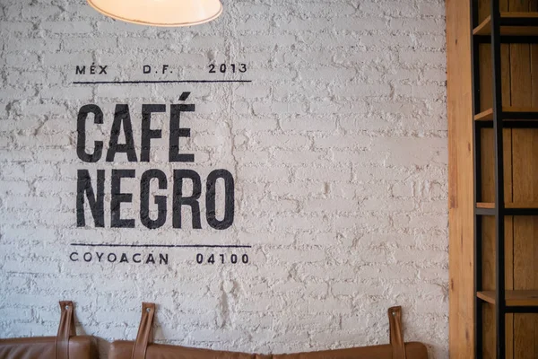 Café preto escrito em espanhol na parede de tijolo branco — Fotografia de Stock