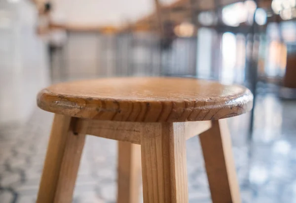 Egyszerű, homályos hátterű, fából készült széklet közeli képe — Stock Fotó
