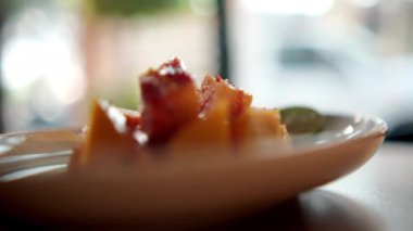 Meksika soslu ve bulanık arkaplanlı bir tabak doğranmış mango.