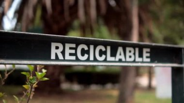 Arka planda bulanık ağaçlar olan geri dönüşümlü çöp için İspanyolca işaret