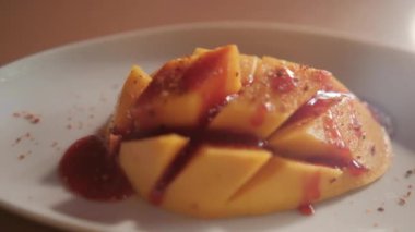 Meksika soslu ve bulanık arkaplanlı bir tabak doğranmış mango.