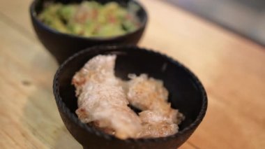 Ahşap yüzeyde domuz derisi ve guacamole kaseleri