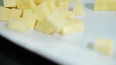 Beyaz tabakta taze doğranmış çedar peyniri.