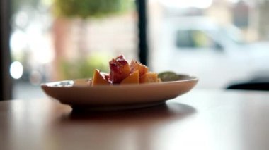 Meksika soslu ve bulanık arkaplanlı bir tabak doğranmış mango.