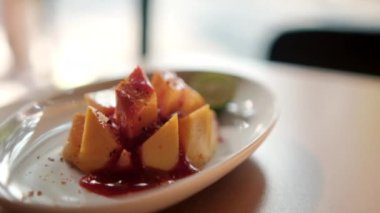 Meksika soslu ve bulanık arkaplanlı bir tabak doğranmış mango.