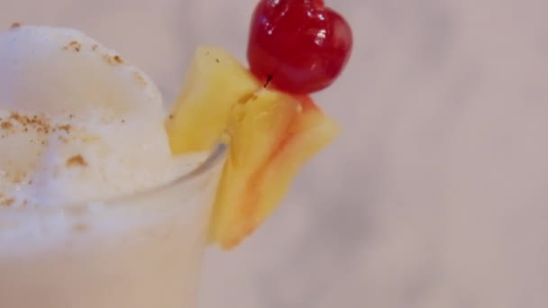 Ananas skiva och körsbär på kanten av glas med vanilj milkshake — Stockvideo