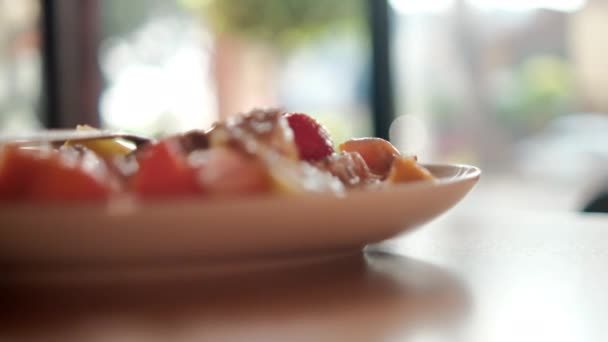 Placa de fruta en rodajas con crema, avena y tenedor encima — Vídeo de stock