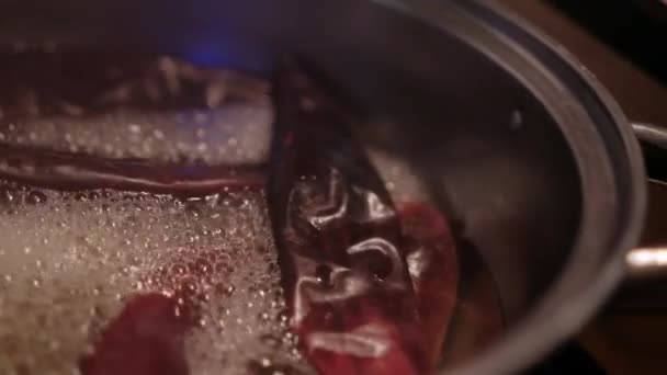 Paprika merah mendidih dalam minyak di dalam panci masak — Stok Video