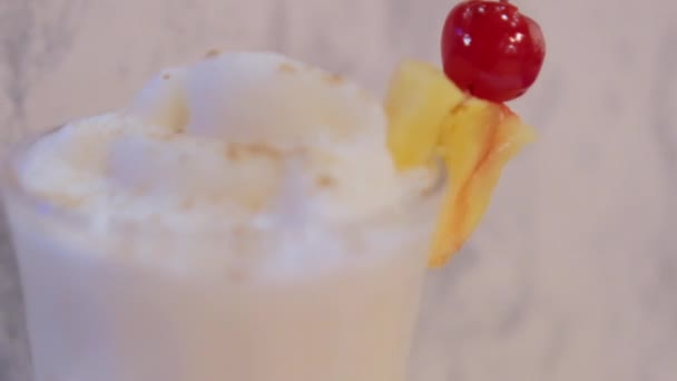 Ananas skiva och körsbär på kanten av glas med vanilj milkshake — Stockvideo