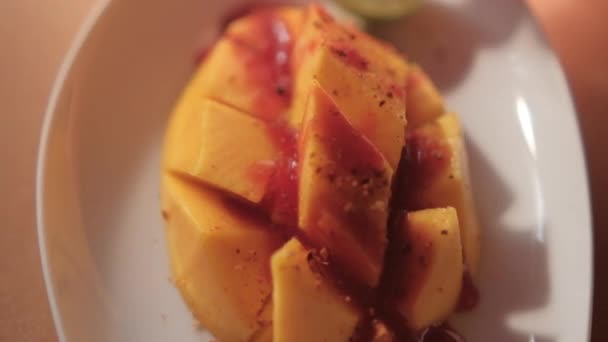 잘 게썬 망고와 멕시코식 샤모아 소스를 곁들인 판 과뿌연 배경 — 비디오