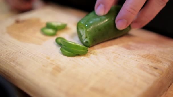 Mãos lentamente cortando pimenta na tábua de corte — Vídeo de Stock