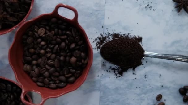 Sked av kaffe och krukor med kaffebönor och anis frön på vit yta — Stockvideo
