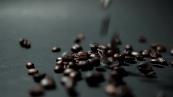黒い表面に焙煎したコーヒー豆をたっぷり注ぐ — ストック動画