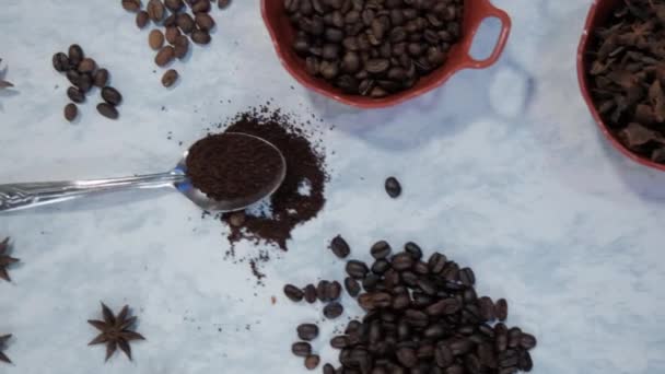 Cucchiaio di caffè e argilla pentola di chicchi di caffè tostati su superficie di marmo bianco — Video Stock