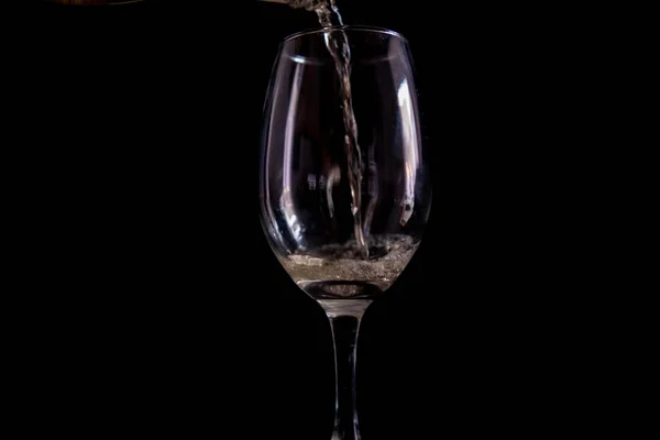 Pouring beer into a glass goblet with black background — Stock Photo, Image
