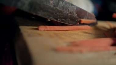 Eller kesme tahtasındaki tatlı patates dilimlerini kesiyor.