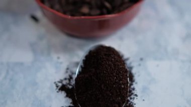 Bir kaşık kahve ve kahve çekirdeği ve beyaz yüzeyde anason tohumu.