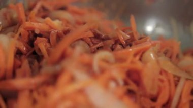 Tahta kaşık yer elması, havuç, domates ve soğan dilimleri karıştırılır.