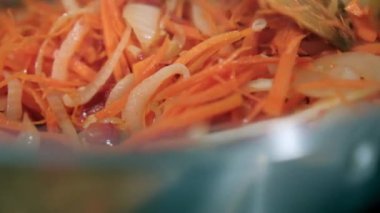 Tahta kaşık yer elması, havuç, domates ve soğan dilimleri karıştırılır.