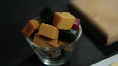 Siyah yüzeyde bir fincan taze meyve ezmesi.