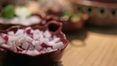 Ahşap masada doğranmış turp, soğan, marul ve limon saksıları.