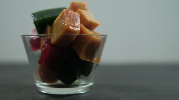 Egy csésze friss gyümölcspaszta kocka fekete felszín felett — Stock videók