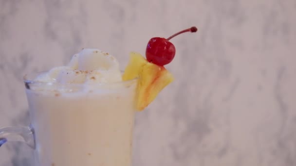 Smaklig vanilj milkshake och ananas skiva ovanför vit marmor bakgrund — Stockvideo