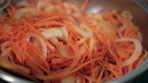 Drewniana łyżka mieszająca ziemniaki, marchewki, pomidory i plastry cebuli w garnku — Wideo stockowe