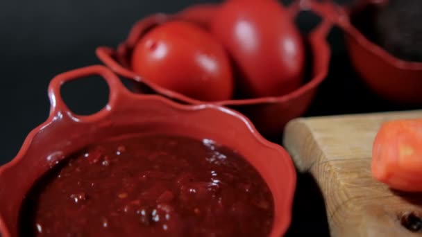 Sauce piquante, tomates et avocats dans des pots en terre cuite avec fond noir — Video