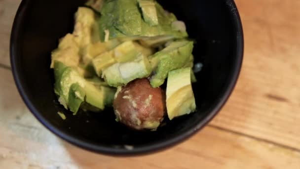 Hackad lök och chilipeppar som hälls i skålen med guacamole — Stockvideo