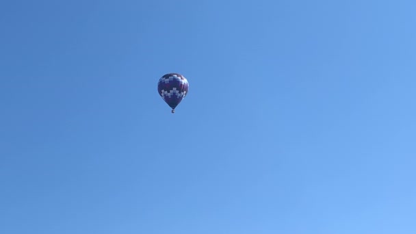 Ballon à air chaud coloré volant dans un ciel bleu clair — Video