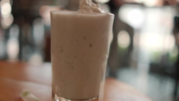 Smaklig utseende frappuccino och milkshake i glas med suddig bakgrund — Stockvideo