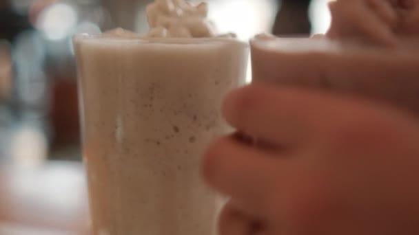 Frappuccino de aparência saborosa e milkshake em óculos com fundo embaçado — Vídeo de Stock