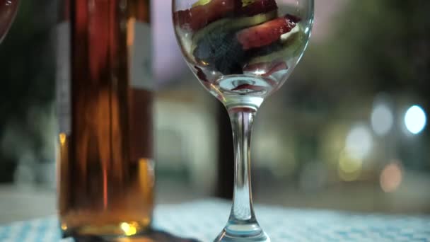 Jahodové a kiwi plátky ve sklenicích na víno s rozmazaným pozadím — Stock video