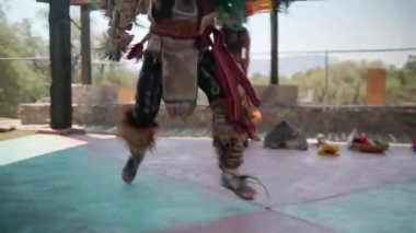 Dansçı arka planda parlak gökyüzü eşliğinde İspanyol öncesi kültürünün dansını yapıyor.