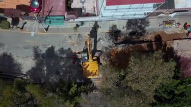 İnşaat alanına park etmiş bir kazıcının hava görüntüsü.