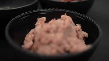 Bir kase kızarmış fasulye ve siyah arkaplanlı tortilla cipsi.