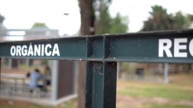Arka planda ağaçlar olan organik ve geri dönüşümlü çöp için İspanyolca işaret