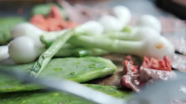 Cipolle verdi messicane, chorizo tritato, nopales e bistecche sottili su una piastra — Video Stock